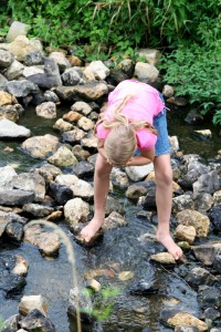Young girl exploring a stream shutterstock_1970733