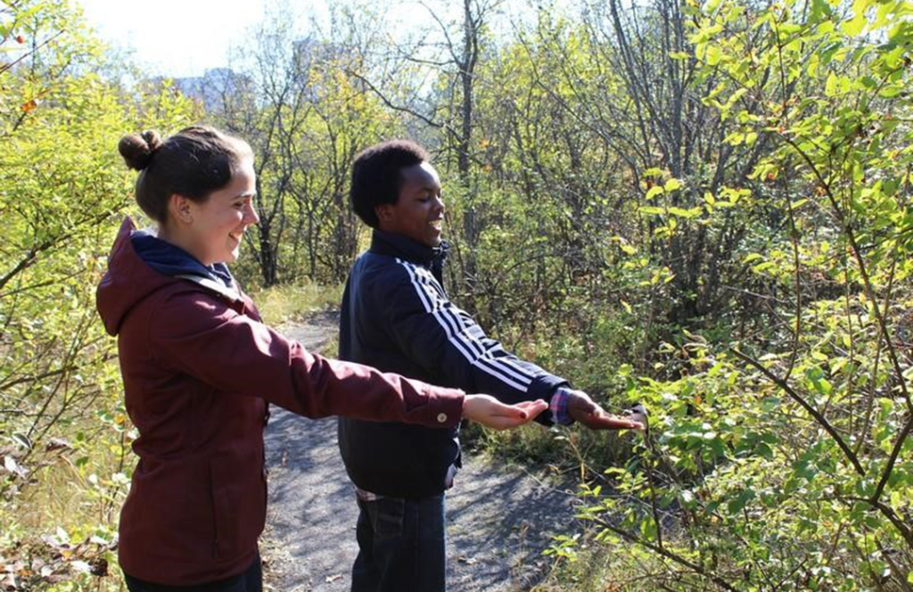 Nature Groups - Photograph of two teens feeding the chickadees.