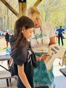 Teacher and Indigenous Knowledge Holder Ozawaa from Wasauksing First Nation pointing out letters on a bag to a young kid